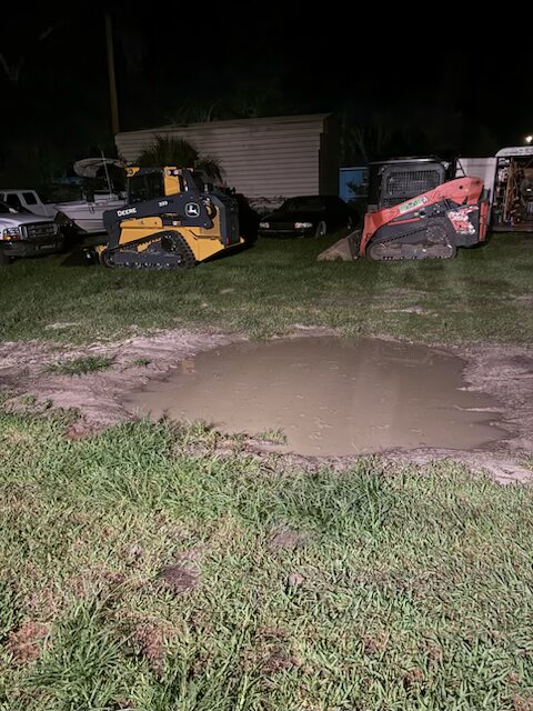 Cleared commercial lot with Deere excavator on trailer